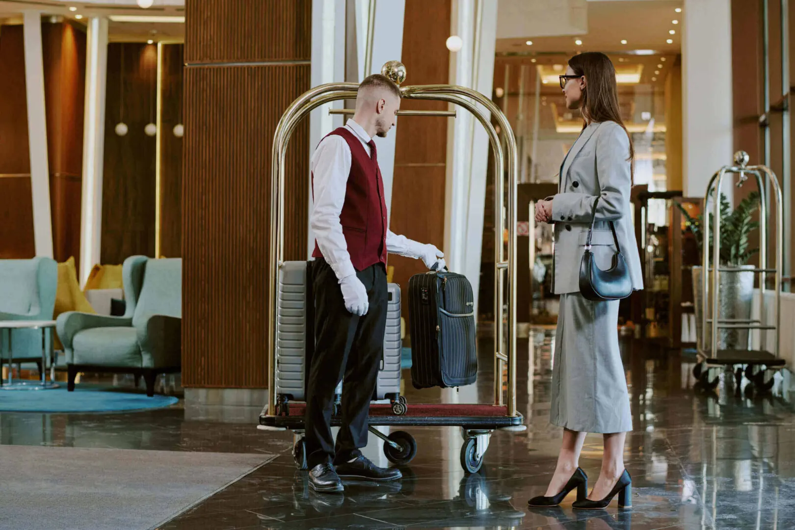 Hotel staff assisting guest with luggage.