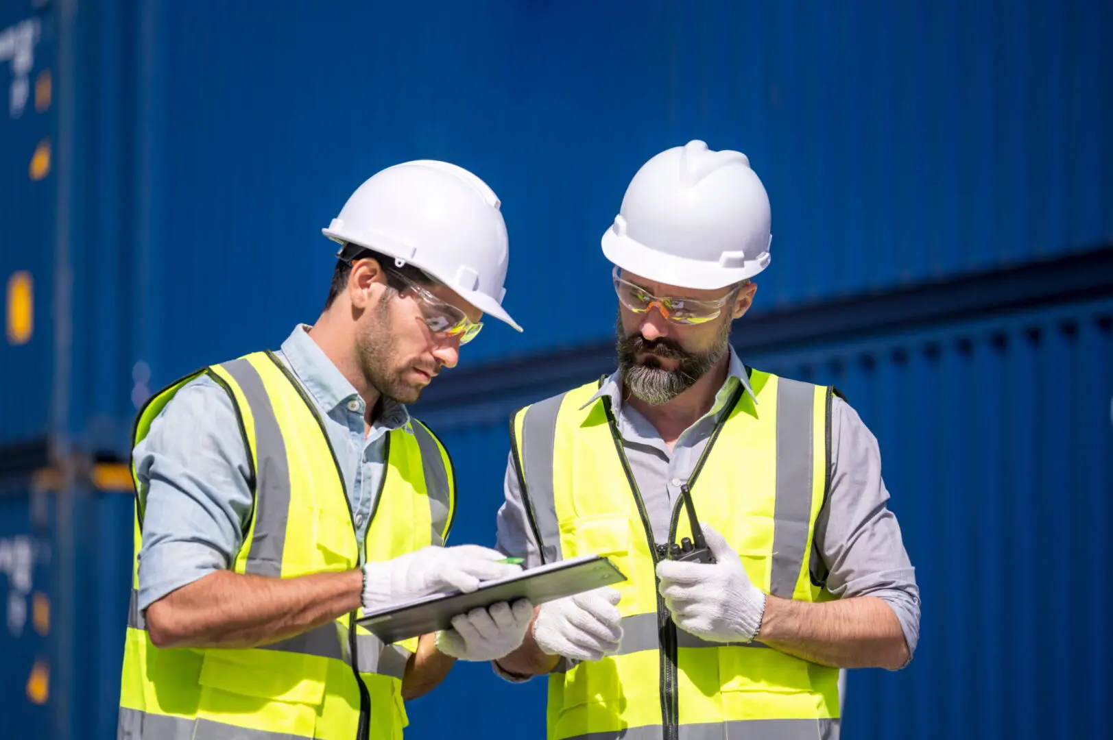 Logistics engineer and inspector working and discuss in shipping container in commercial transport port