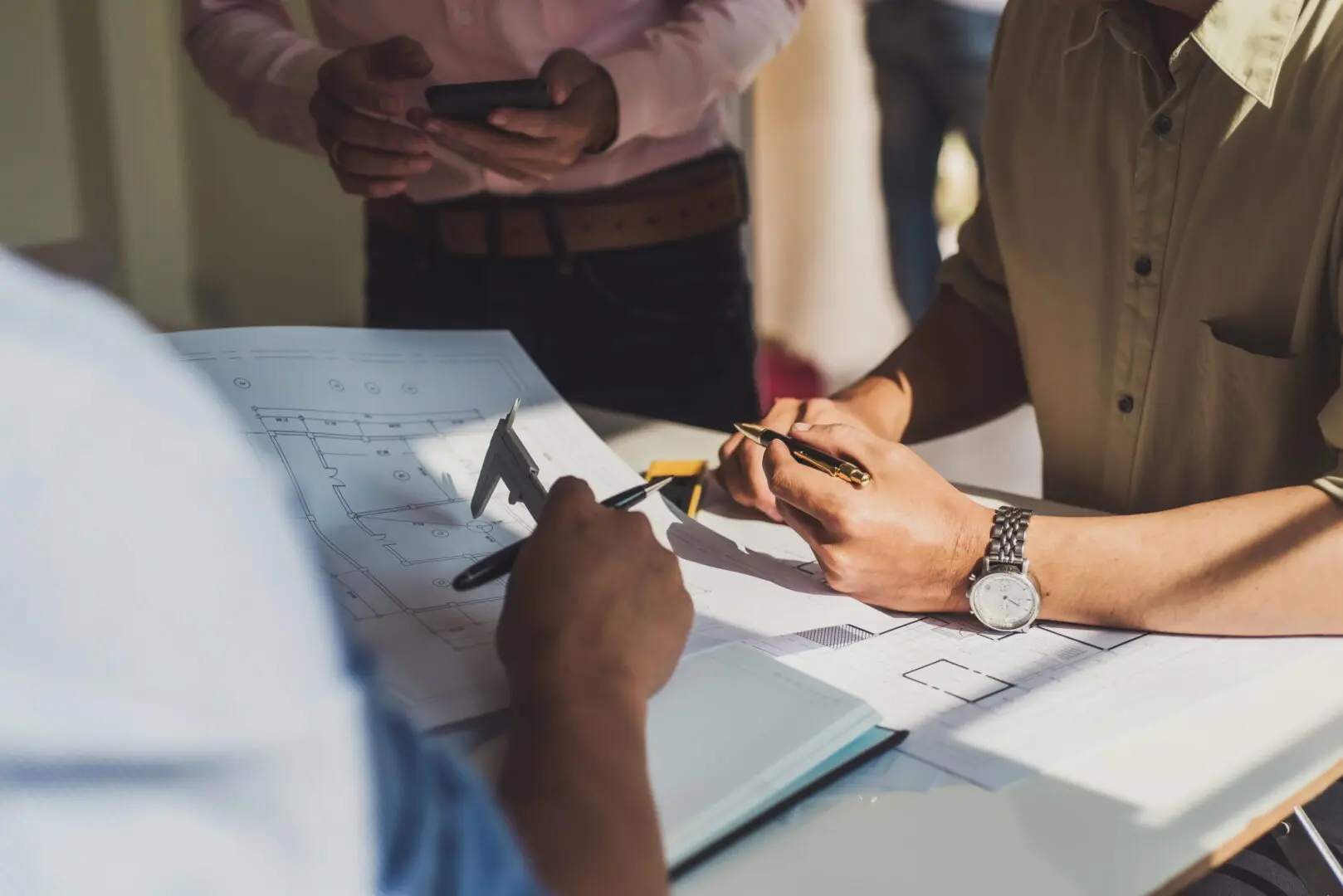 Architects reviewing building blueprints at table