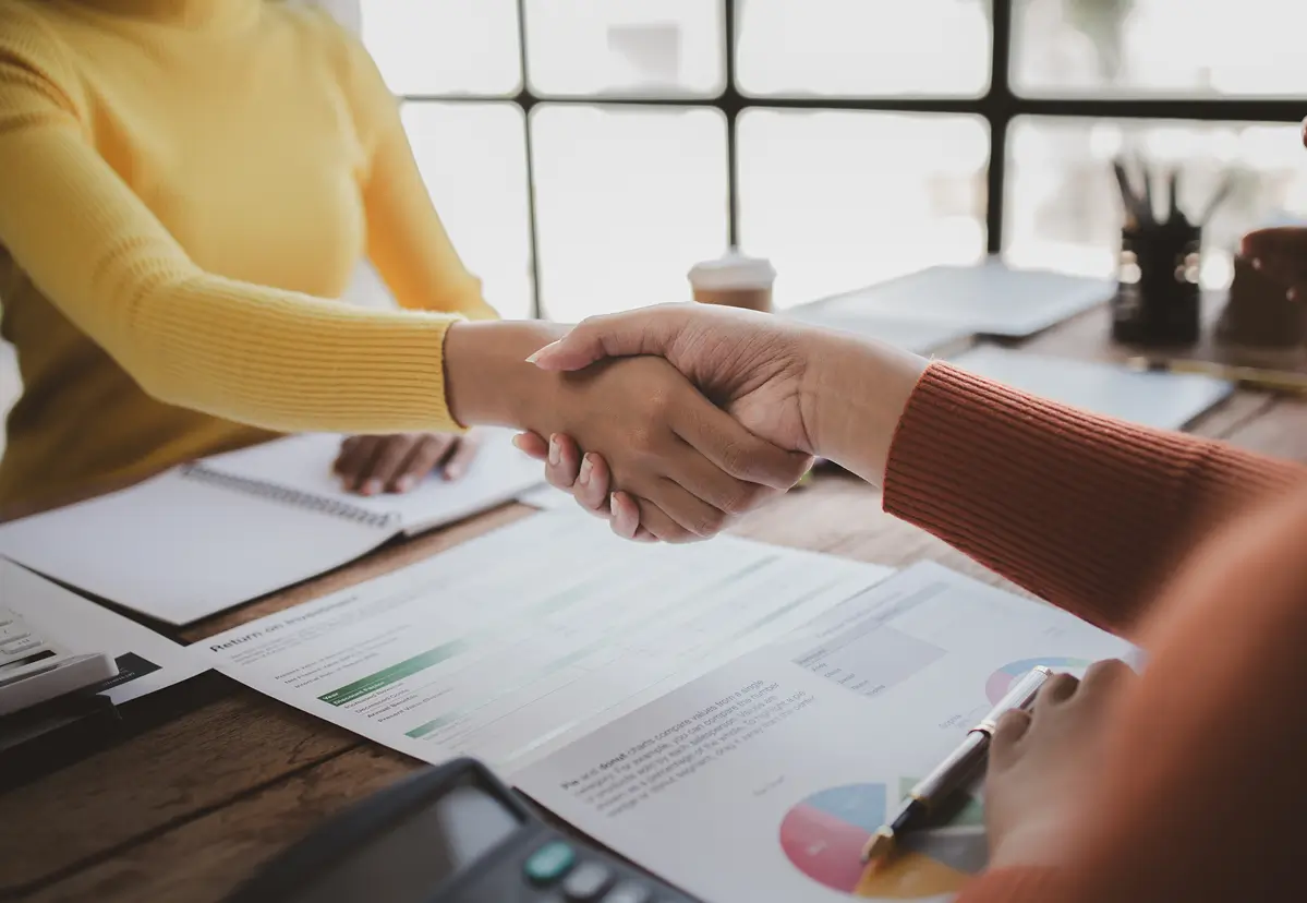 Business handshake over financial documents